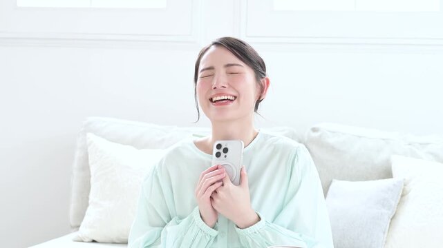 スマホを見て喜ぶ日本人女性