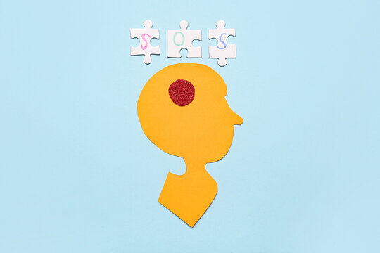 Paper human head with word SOS on blue background. Multiple Sclerosis Awareness Month