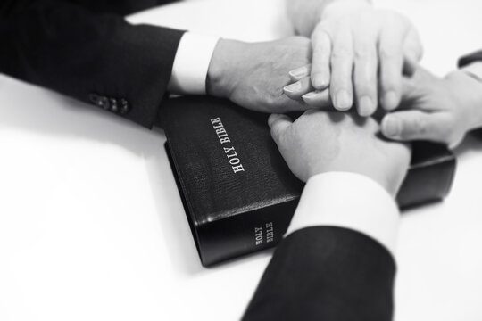 Christians praying and worshipping together with their hands on the Bible, Background of the Gospel and Faith Prayer Time
