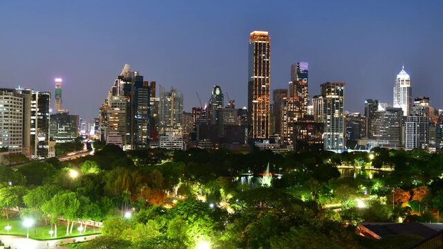 High angle view of Lumphini Park and Bangkok city skyline at night with illuminated skyscrapers, Thailand