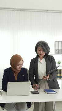 Muslim female applicant consulting with hiring manager in modern office