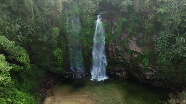 Th&aacute;c Ti&ecirc;n waterfall aerial hover capturing split cascades, emerald foliage, and the natural rock bowl below, Vietnam.