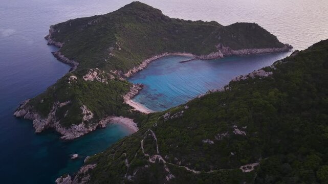 Aerial view of Porto Timoni double beach in Corfu, Greece at dusk. Stunning twin bays with turquoise water surrounded by lush green hills