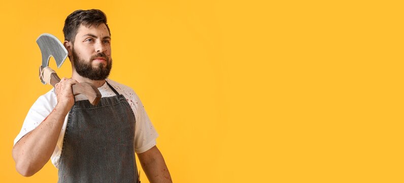 Man dressed as butcher with ax for Halloween on yellow background with space for text