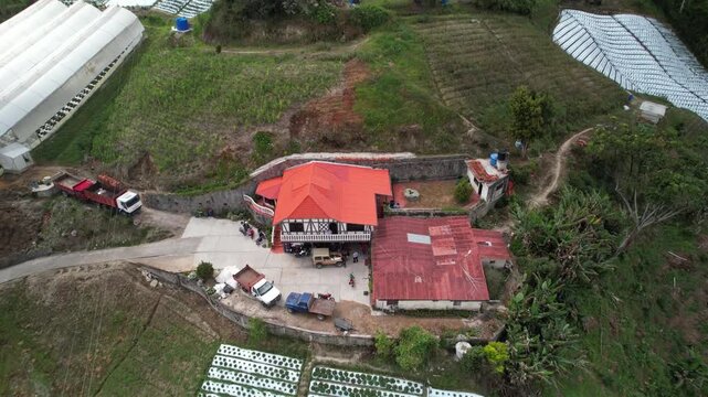 Agricultural activity in a mountainous rural landscape, with cultivated plots, access roads, and scattered vegetation. farming infrastructure, and sustainable rural living.
