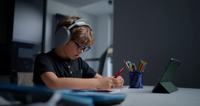 Young Boy Gestures And Clarifies Homework Response To Remote Educator Using Tablet And Colored Markers