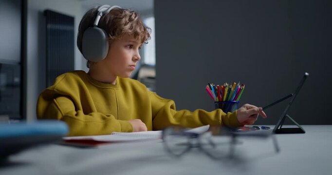 Young Student Carefully Picking Crayons While Sitting At Neatly Organized Desk With Art Tools