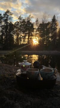 Vertical screen outdoor tea ceremony with chaban and teaware in sunset sun rays creating peaceful mindfulness and wellness retreat mood