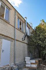 Obraz premium Exterior view of a light brick building with windows and a metal
