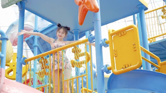 Cheerful woman tourist in bikini swimsuit running on the swimming pool water park, waves shake hand friendly welcome greeting, relaxing vacation happy holiday at luxury hotel tropical resort villa
