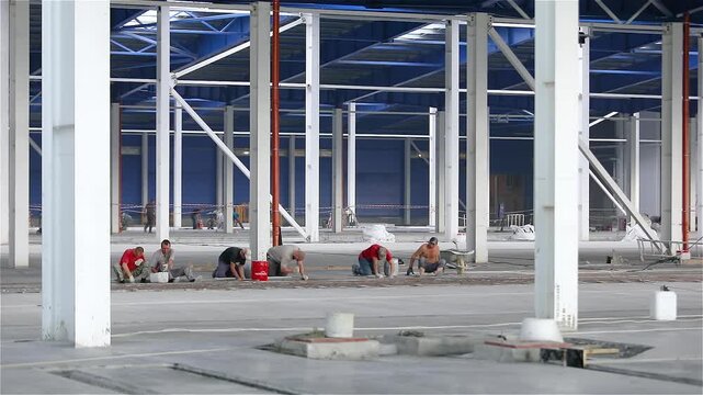Installation of reinforced concrete floors in a large industrial or commercial building. Construction of a large modern factory in its final stages. Industrial factory construction inside. Intrior