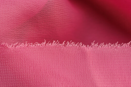 Soft pink chiffon fabric with frayed edge close up delicate textile background airy transparent cloth texture