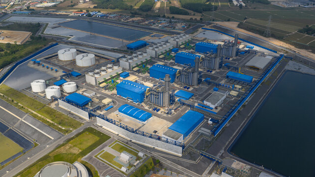 Aerial view of Sriracha Power Plant GSRC featuring blue industrial buildings, white storage tanks, and cooling towers in Tambon Khao Khan Song, Chang Wat Chon Buri, Thailand.