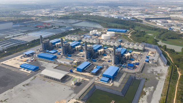 Aerial view of Sriracha Power Plant GSRC featuring blue industrial buildings, smokestacks, and cooling towers in Tambon Khao Khan Song, Chang Wat Chon Buri, Thailand.