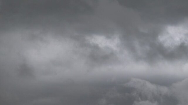 Ominous Sky's Embrace: An abstract atmospheric photograph reveals a dramatic expanse of gray clouds, showcasing the raw power and beauty of nature's tempestuous moods. 