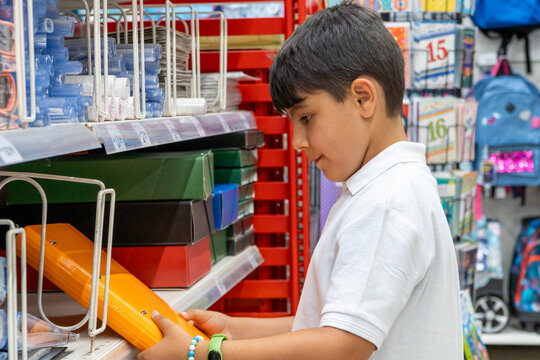 Alpha generation boy choosing school folder on the shopping mall