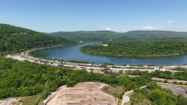 Wide aerial drone footage of the Tennessee River curving around forested Lookout Mountain in Chattanooga Tennessee with South Broad Street development visible in the foreground