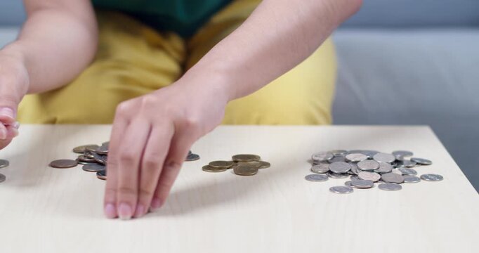A close-up view of hands sorting coins highlighting personal finance activities at home.