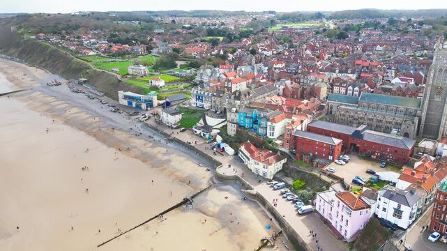 Seaside views of the holiday town of Croma on the Norfolk coast. Sandy beach and sea. Holiday destination, vintage photograph. North Sea coastline, Chapel, church and pier on the promenade, tourists.