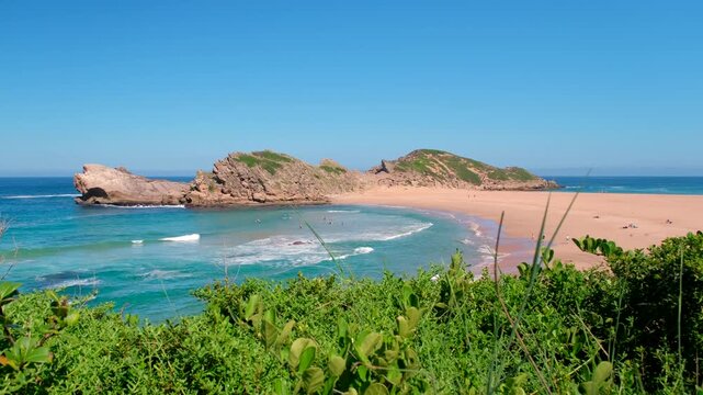 The Island connected via scenic sandy tombolo to Robberg peninsula with some travelers swimming and sunbathing, Plettenberg Bay
