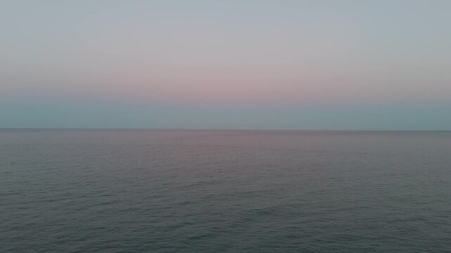 A minimalist and serene aerial shot of the Adriatic Sea horizon during the blue hour at Spiaggia del Lido delle Rose, Italy.