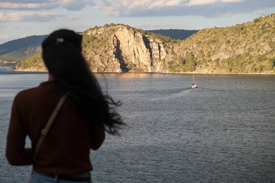 Una mujer observa un barco navegando en el pantano de Entrepe&ntilde;as, Guadalajara, Espa&ntilde;a.