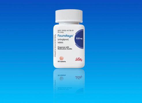 Studio shot of bottle of foundayo weight loss; pill from Eli Lilly on blue background with copy space. Copenhagen, Denmark - May 1, 2026..