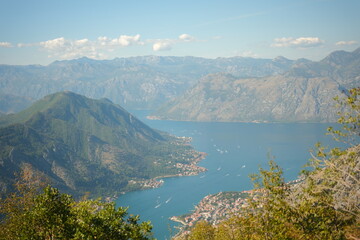 Fototapeta premium Panoramic view of the Bay of Kotor (Boka Kotorska) in Montenegro. Scenic coastal landscape with deep blue sea, majestic mountains, and a small town at the foot of the cliffs.