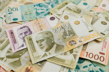 Obraz premium Mixed Serbian dinar banknotes are scattered across a wooden surface in a layered cash arrangement. Currency and finance concept for banking, budgeting, payment and economic illustration