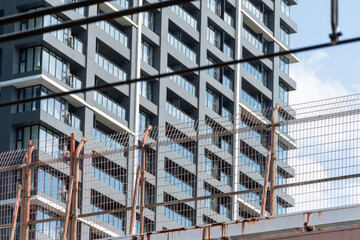 Urban development scene with rusty wire fence and new residential tower © TOSHIAKI ISHII