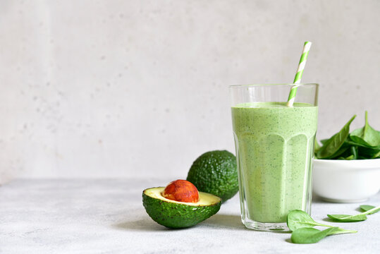Detox avocado spinach smoothie in a tall glass. Top view with copy space.