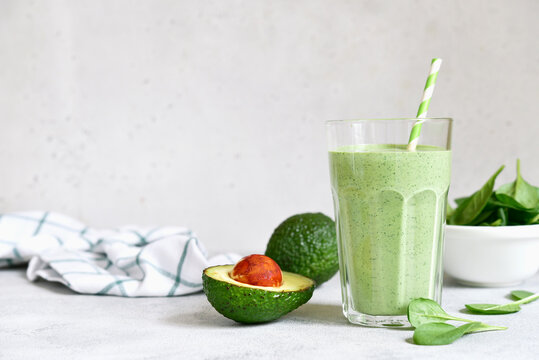 Detox avocado spinach smoothie in a tall glass. Top view with copy space.