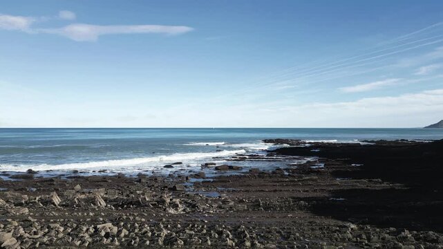 Majestic coastal scenery at Sakoneta beach in Spain, featuring the famous flysch rock formations extending into the Cantabrian Sea under a clear blue sky on a beautiful sunny day