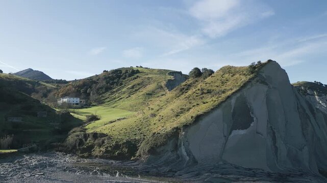 Stunning aerial perspective capturing the unique flysch geological formations and lush green hills of Sakoneta Beach, part of the Basque Coast UNESCO Global Geopark in northern Spain