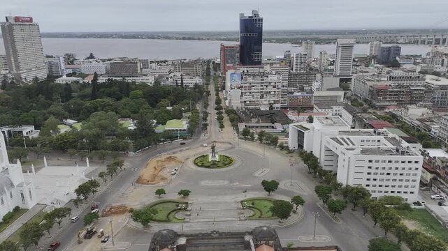 Drone rises up over Avenida Samora Machel facing south over Independence Square on an overcast day in Maputo, Mozambique