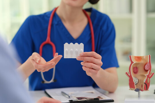 Caucasian female clinician holding dental model and explaining teeth alignment and prosthesis options in clinical office,