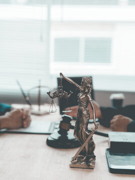 The lawyer advised his client on contractual documents, using a brass scale to explain legal points in court.