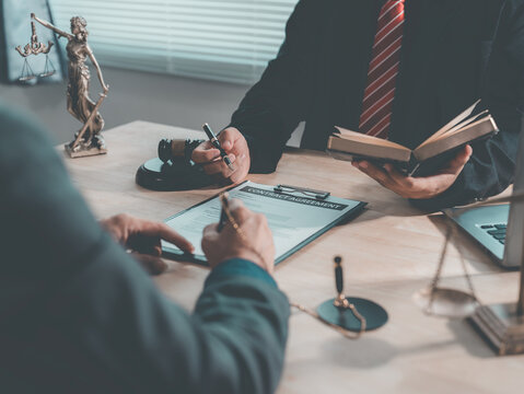 The lawyer advised his client on contractual documents, using a brass scale to explain legal points in court.