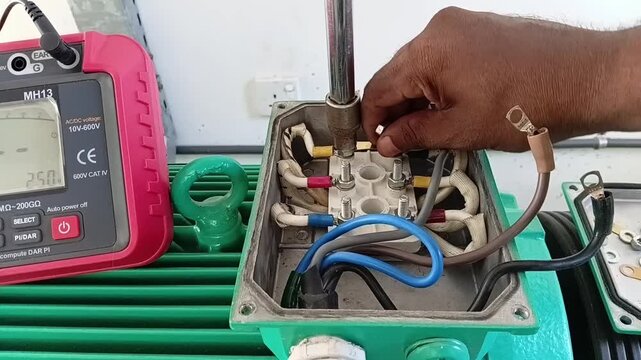 Motor Testing Sequence: Technician Disconnecting Star Delta Winding Links and Power Cables Inside Motor Terminal Box