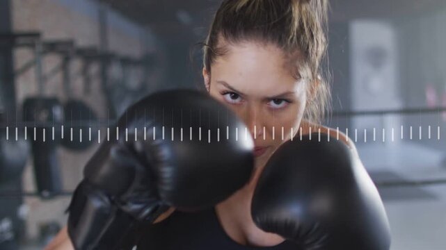 Woman boxer raising guard to camera, throwing gloved jabs blurring lens waveform pulsing training