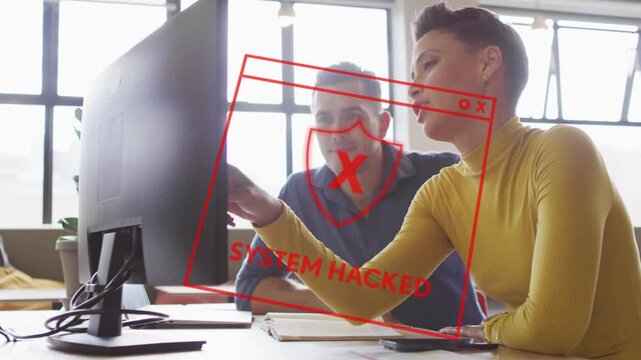 Woman pointing at monitor as red SYSTEM HACKED alert emerging IT coworker leaning, stopping breach