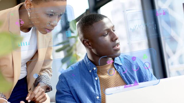 Lead leaning and pointing at laptop, causing charts showing business data while junior reviewing