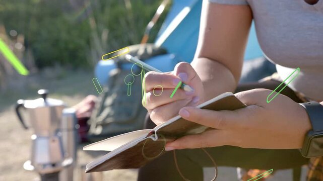 Woman opening notebook, writing travel notes while green icons growing over hands, drifting right