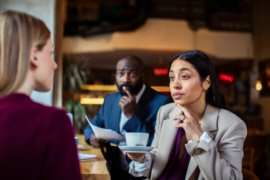 Business professionals conducting job interview in cafe