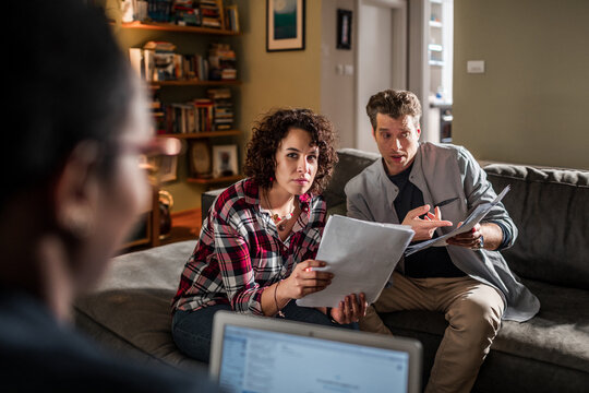 Couple discussing finances with advisor at home