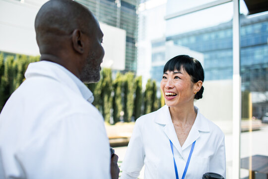 Healthcare professionals chatting outside modern hospital