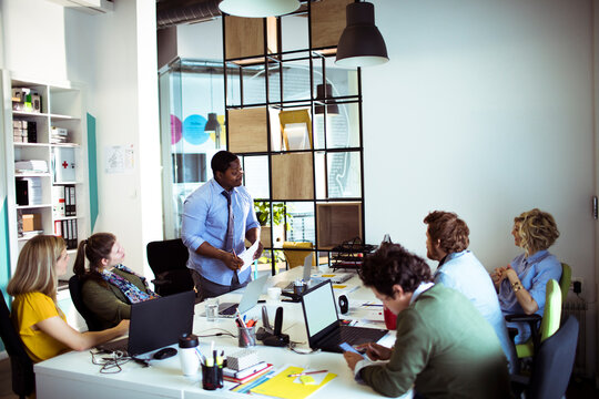 Coworkers collaborating during team meeting in modern office