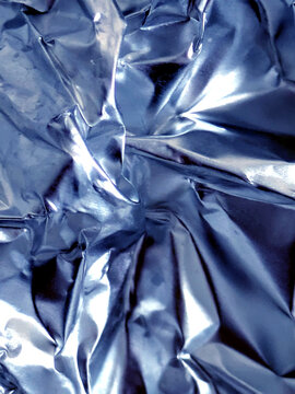Shiny crumpled abstract silver foil close up background