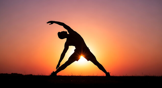 Person doing yoga triangle pose at sunset