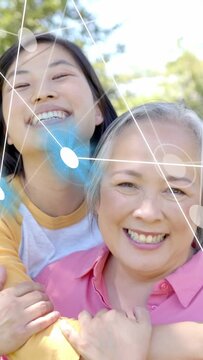 Vertical video: Daughter starting hug behind mom in park, sharing bond, tech overlay tracing faces